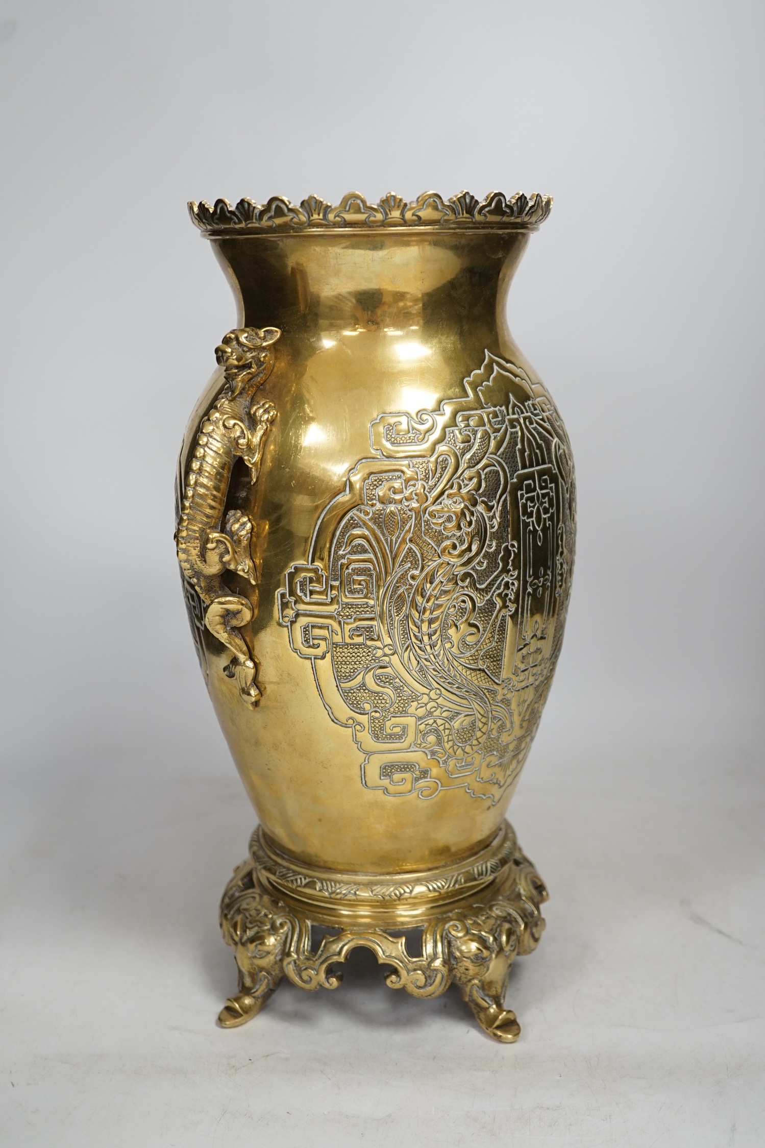 A Chinese dragon handled brass vase with ornate stand, 34cm high. Condition - the base to vase is missing